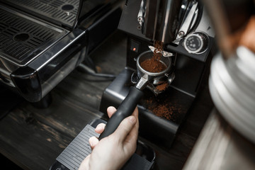 The process of grinding coffee professional machine for the bar in a modern cafe. Close-up