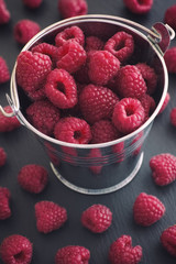 Ripe raspberries in a small bucket