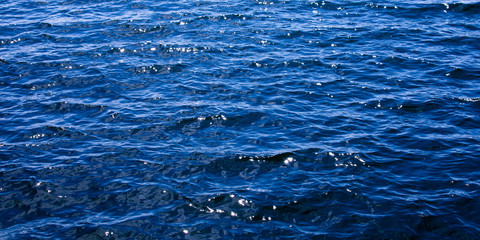 The brilliant blue water of the Baltic Sea glistens in the sun a few days after midsummer, near the Island of Nicklösa in the Åland Islands, Finland.