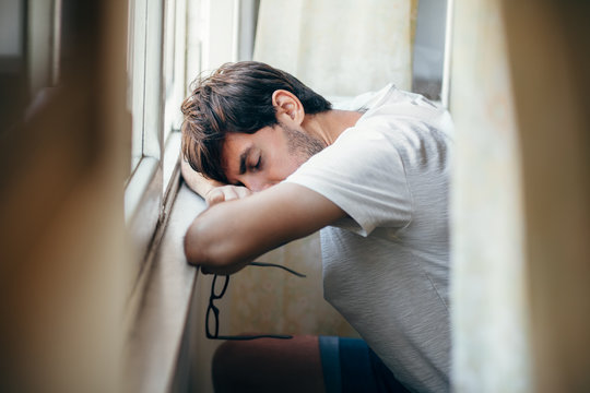 Tired young man sleep near window