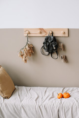  Interior details of children's room. Decorative wooden hanger with bag  on white wall. Exotic bedroom interior