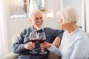 Happy anniversary. Grey-haired man smiling happily while hugging his short-haired wife