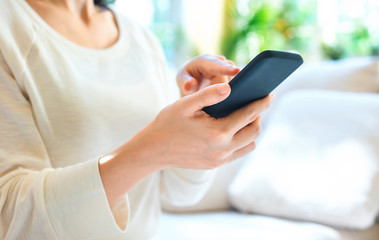 Woman using her smartphone in a bright interior room