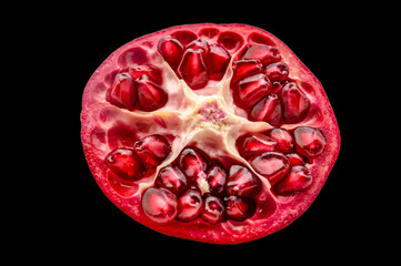 Fototapeta premium red garnet in cut with grains on a black background isolated