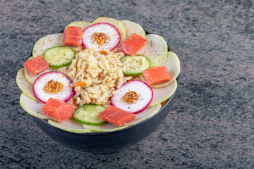 Poke bowl trand. Raw fish, rice and halhy vegetables on wooden background