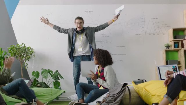 young group of business students celebrating caucasian team leader man dancing funny enjoying victory dance friends celebrate successful teamwork in happy diverse office presentation