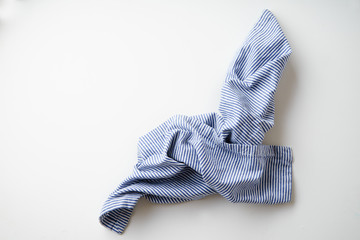 Striped blue and white textile napkin folded on white background. Food styling element