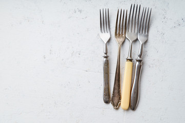 Various vintage forks on concrete background with copy space