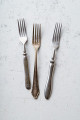 Various vintage forks on concrete background