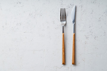 Knife and fork on concrete stone background with copy space
