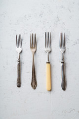 Various vintage forks on concrete background