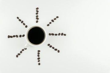 Coffee makes us feel good concept, top view of a cup of coffee with the rows of coffee beans on the white table.