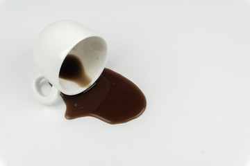 close up of a cup of coffee spilled on the white table