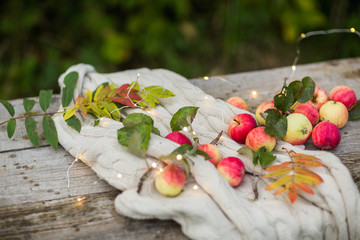 apples on a wooden background in the autumn street, lights