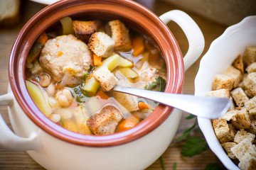 vegetable soup with beans and meatballs in a ceramic bowl