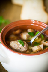 vegetable soup with beans and meatballs in a ceramic bowl