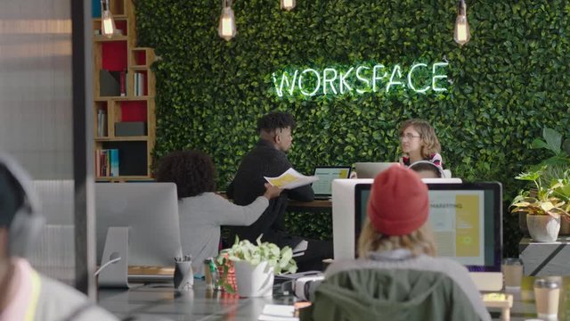 multi ethnic business people brainstorming working together creative marketing team sharing ideas discussing strategy enjoying teamwork in trendy startup office workspace