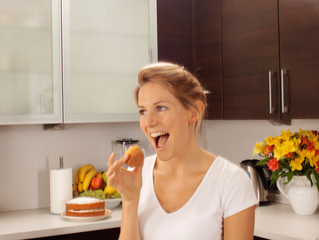 WOMAN IN KITCHEN EATING FAIRY CAKE / CUPCAKE