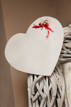 Cuore in carta sopra una superficie in vimini e un fiocco, rosso