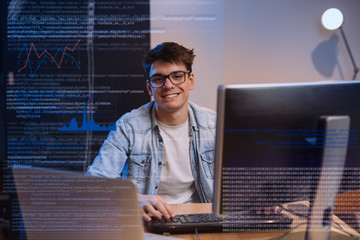 young programmer working on computer in his home office