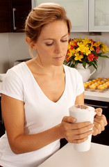 Obraz na płótnie Canvas WOMAN IN KITCHEN DRINKING LATTE COFFEE