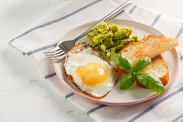 healthy breakfast. egg, avocado, toasts and basil