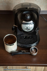 Photo of coffee maker, mug, spoon on table