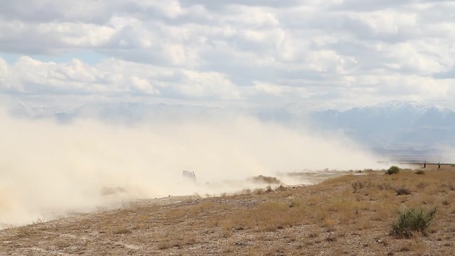 car finishes in clouds of dust during the rally races