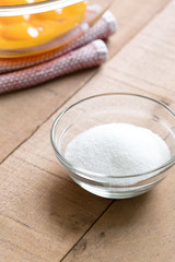 Bowl of sugar with a dish of egg yolks in the background