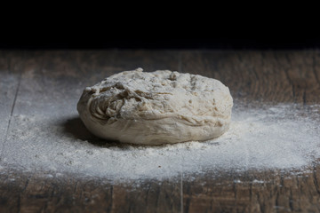 Studio photo of a ball of bread close-up and flour on table artistic conversion