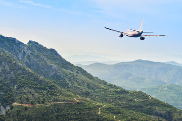 Fototapeta na wymiar Airplane flying over the mountains. Travel concept.