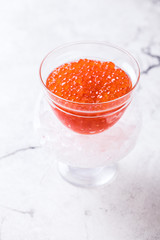 Salmon and trout red caviarin a glass jar on a light marble background. Seafood  Healthy Food Concept. Snack.Copy space for Text