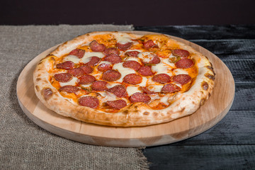 Hot Homemade Pepperoni Pizza with salami, cheese, sausage on dark background