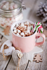 Pink mug of hot chocolate with marshmallows on table, top view