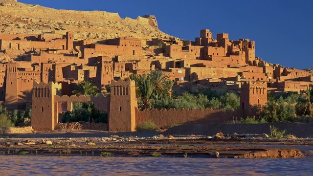 Stone towers and buildings in ksar of Ait-Ben-Haddou - an ancient fortified village along the former caravan route between the Sahara and Marrakech in present-day Morocco. Sunset time. 4K, UHD