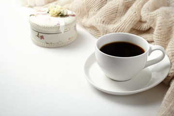 A Cup of fragrant black coffee and a textured wool blanket. Warm tone
