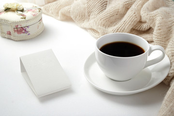 A Cup of fragrant black coffee and a textured wool blanket. Warm tone