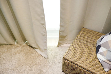 Beige curtains. Wicker furniture with pillow. Living room interior.