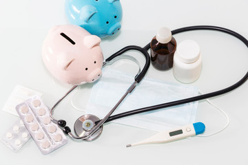 A piggy bank sits on top of pills to pay for rising drug prices. Health care