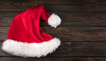 Obraz na płótnie Canvas A Santa Claus hat on a wooden background.