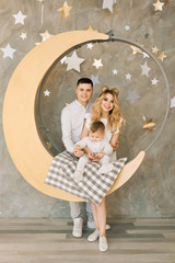 New year's portrait of young parents with a young son on a pendant . New year and Christmas concept