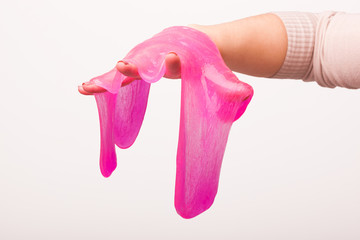 a toy for children mucus and liquid flowing on hand on a white background