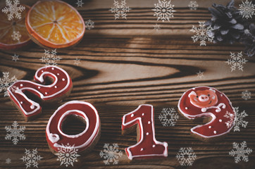 Christmas card on wood background gingerbread red numbers 2019 with slices of apelstina white snowflake