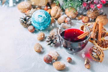 Fototapeta na wymiar Christmas composition. Glass of red mulled wine on table with cinnamon sticks, Christmas decorations.