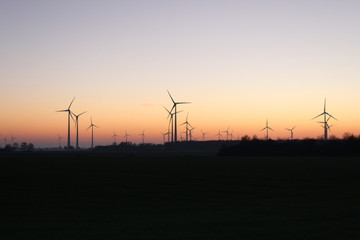 Fototapeta na wymiar Wind farm in front of autumnal red sunset