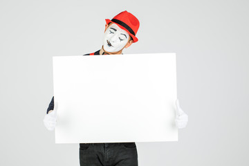 happy MIME artist holding a blank white Board, on a white background.