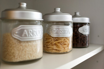 Different types of ingredients for healthy cooking in glass jars in the kitchen.