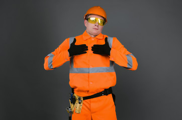 Guilty builder worker justifies about lateness of construction and spreads his hands isolated on blue background. Construction mistake.