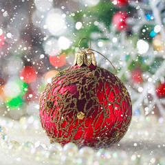Christmas red ball on artificial snow, defocused background