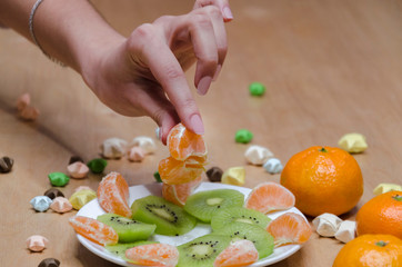 Obraz na płótnie Canvas female hand with a slice of tangerines